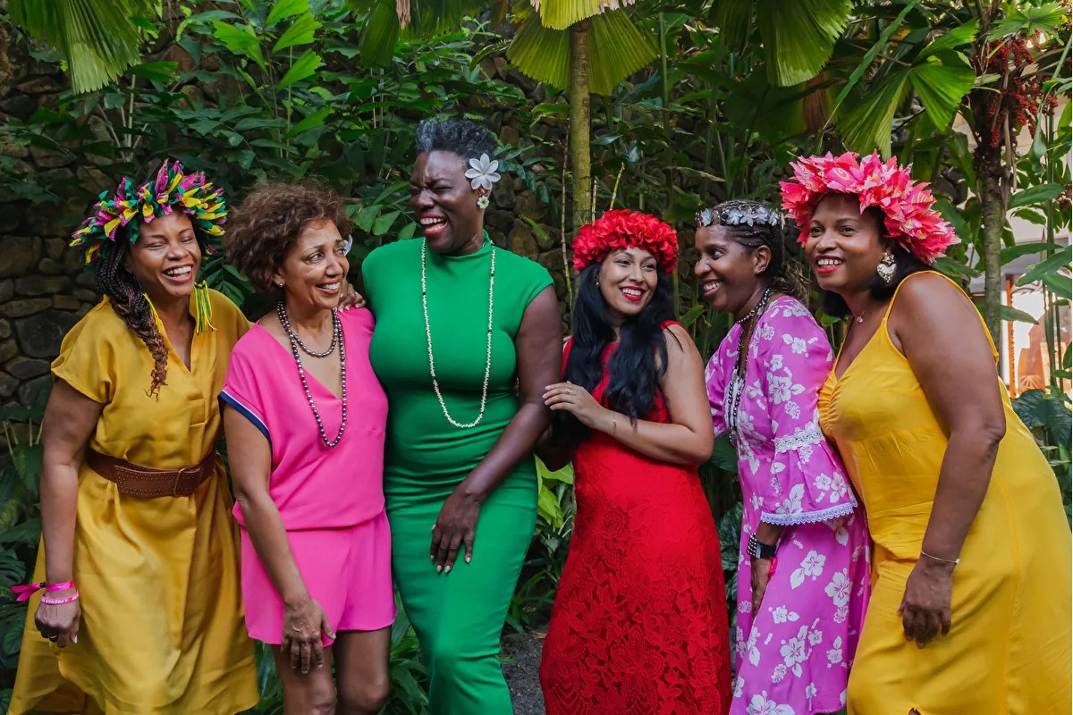 Un groupe d’Amazones souriantes, en tenues colorées et couronnes de fleurs