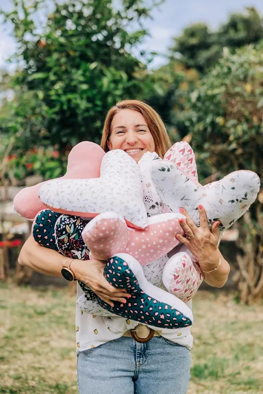 Une femme tenant des coussins en forme de cœur